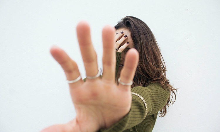 A woman with her face covered by a hand
